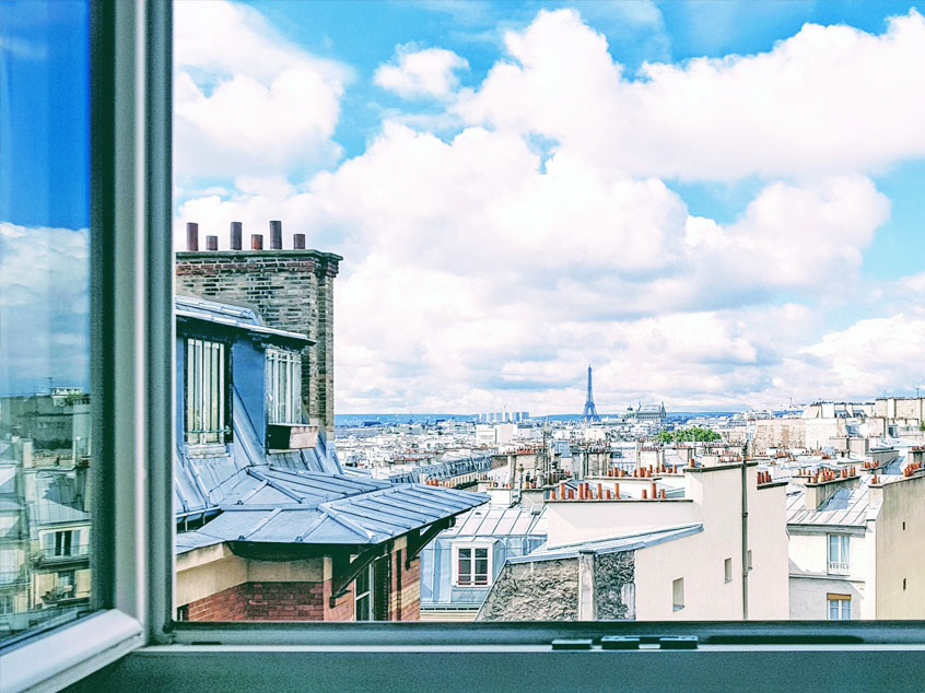 Vue sur les toits de Paris depuis la fenêtre d’un logement