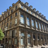 Façade en pierre de l’ancienne Salle Ventadour à Paris, transformée en immeuble de bureaux.